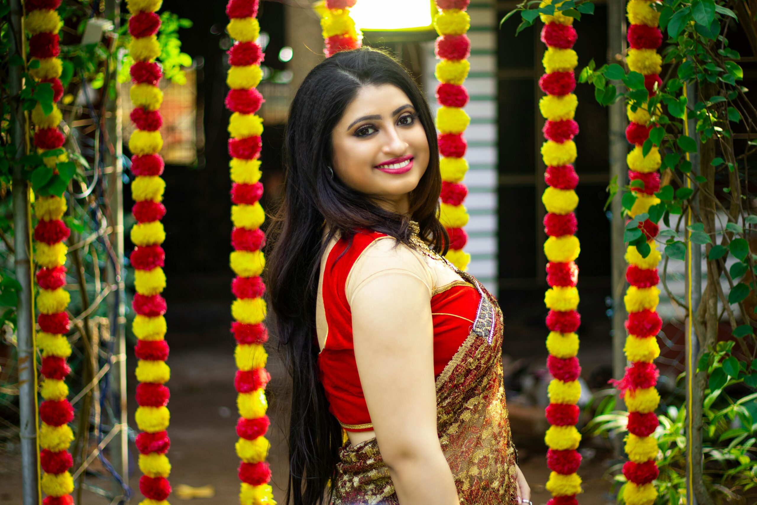 Elegant South Asian woman in traditional outfit with festive background in Kolkata.